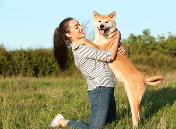 Photo of Young woman with adorable Akita Inu dog in park