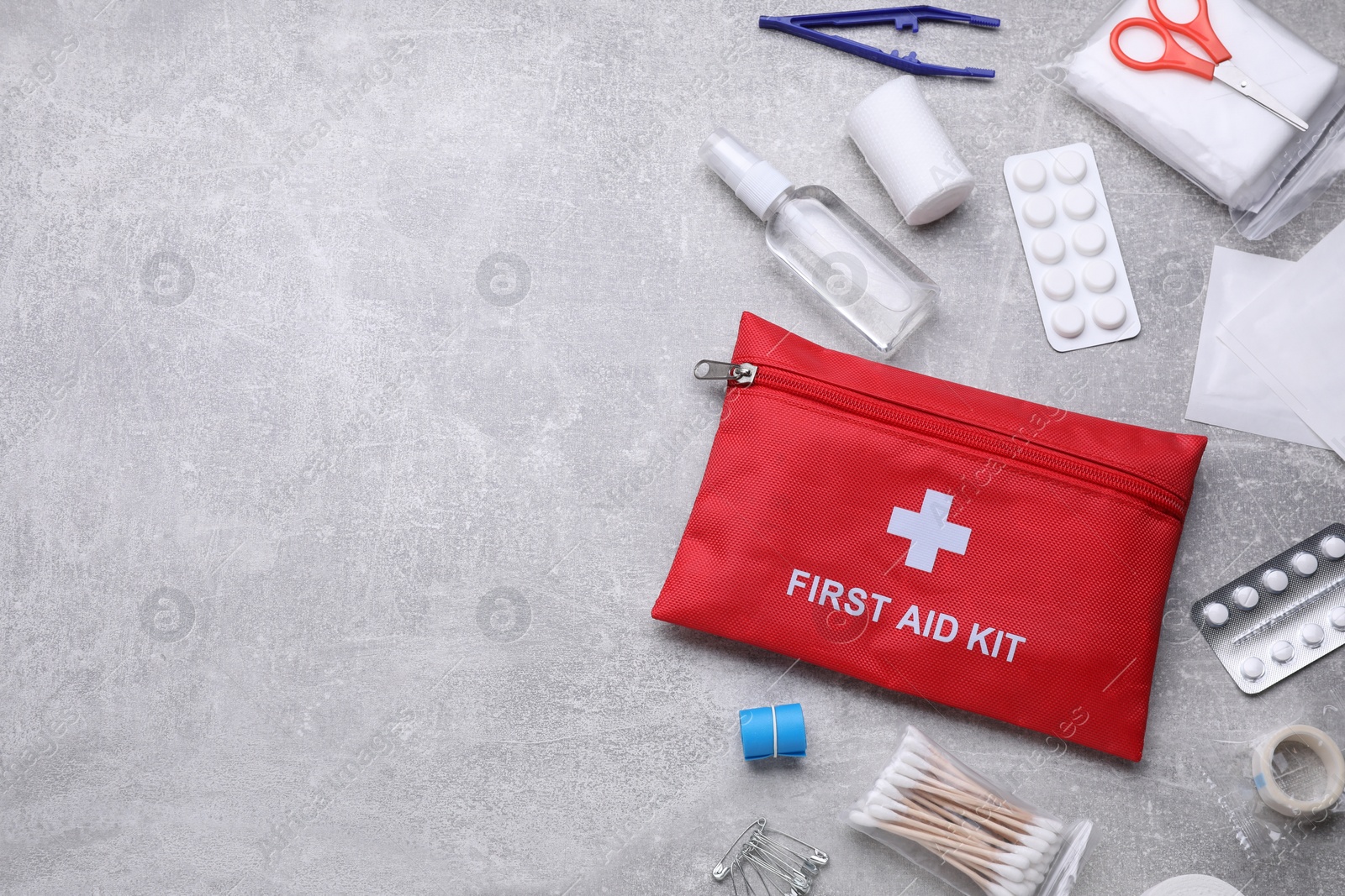 Photo of Flat lay composition with first aid kit on light gray background, space for text