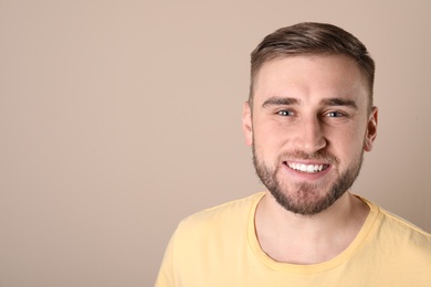 Photo of Young man with healthy teeth on color background. Space for text