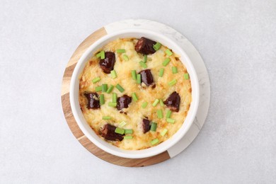 Photo of Tasty sausage casserole with green onions in baking dish on white table, top view