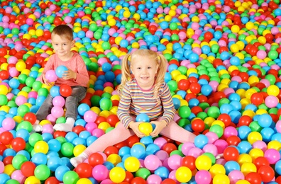 Photo of Cute children playing in ball pit indoors