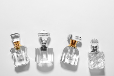 Photo of Different elegant perfume bottles on white background, top view