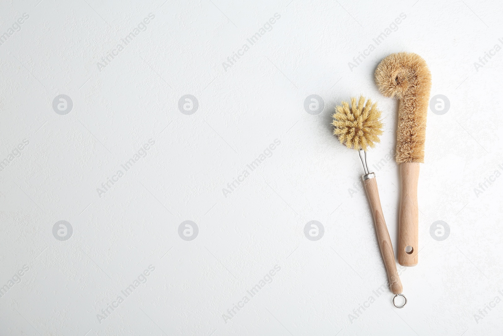 Photo of Cleaning brushes on white background, flat lay and space for text. Dish washing supplies