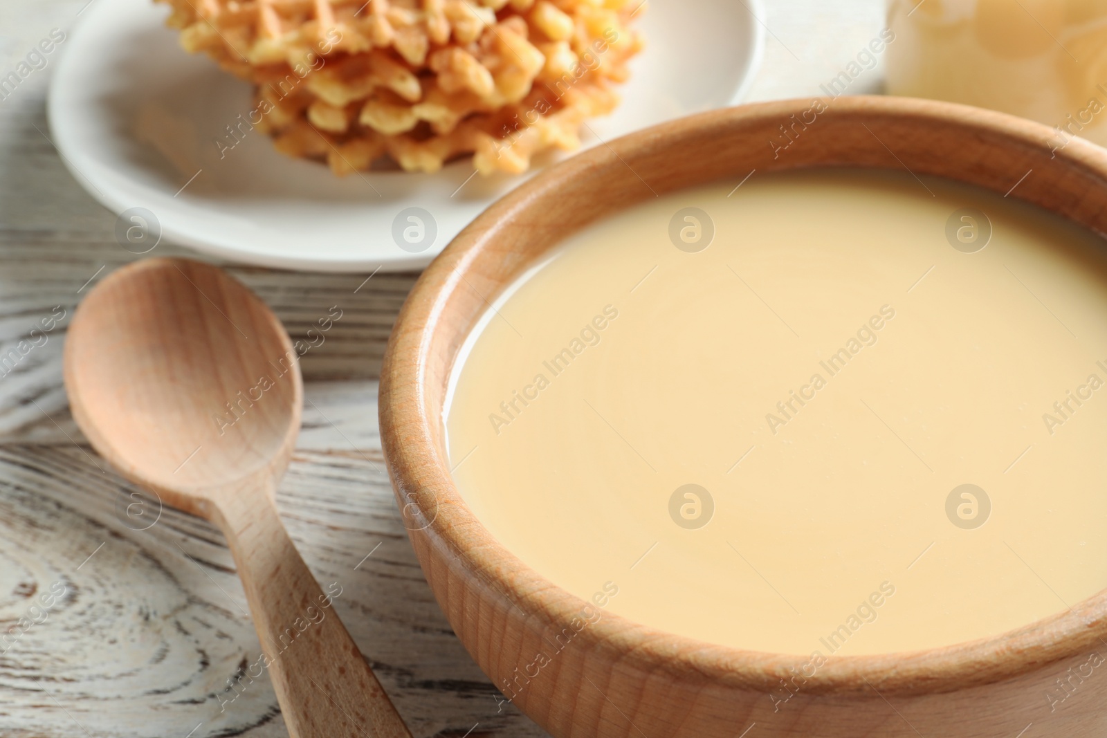 Photo of Bowl with condensed milk served on table, closeup. Dairy products