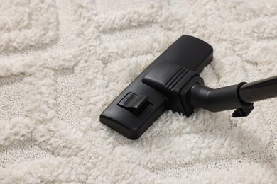 Photo of Hoovering carpet with modern vacuum cleaner, closeup