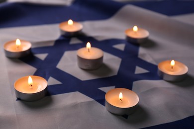 Photo of Burning candles on flag of Israel. Holocaust memory day