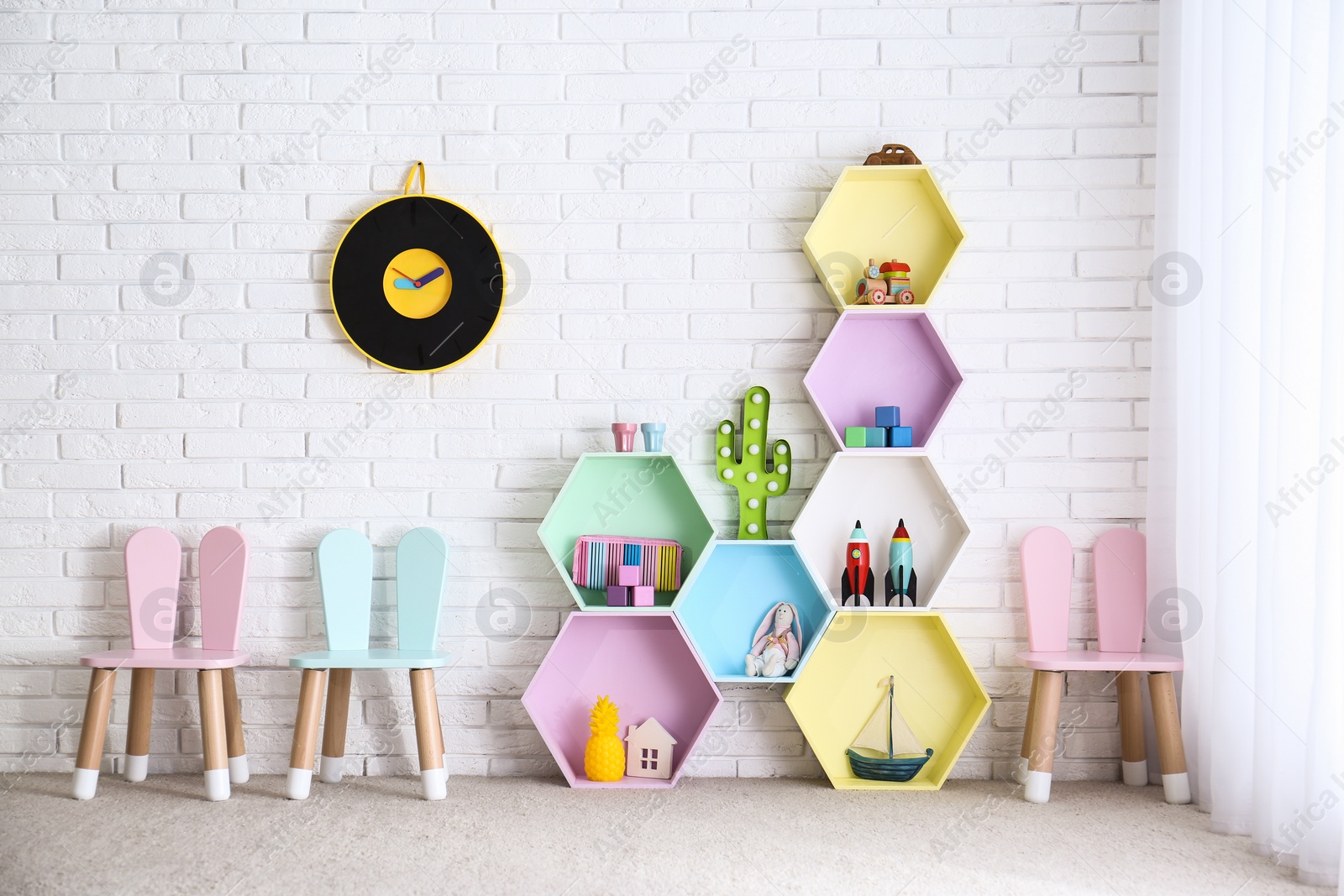 Photo of Child room interior with colorful shelves near brick wall