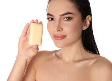 Young woman with soap bar on white background