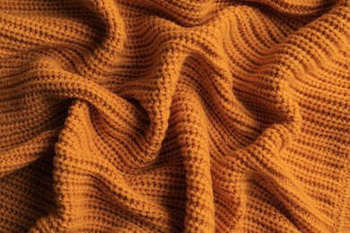 Photo of Beautiful orange knitted fabric as background, top view