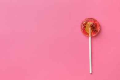 Sweet colorful lollipop with berries on pink background, top view. Space for text