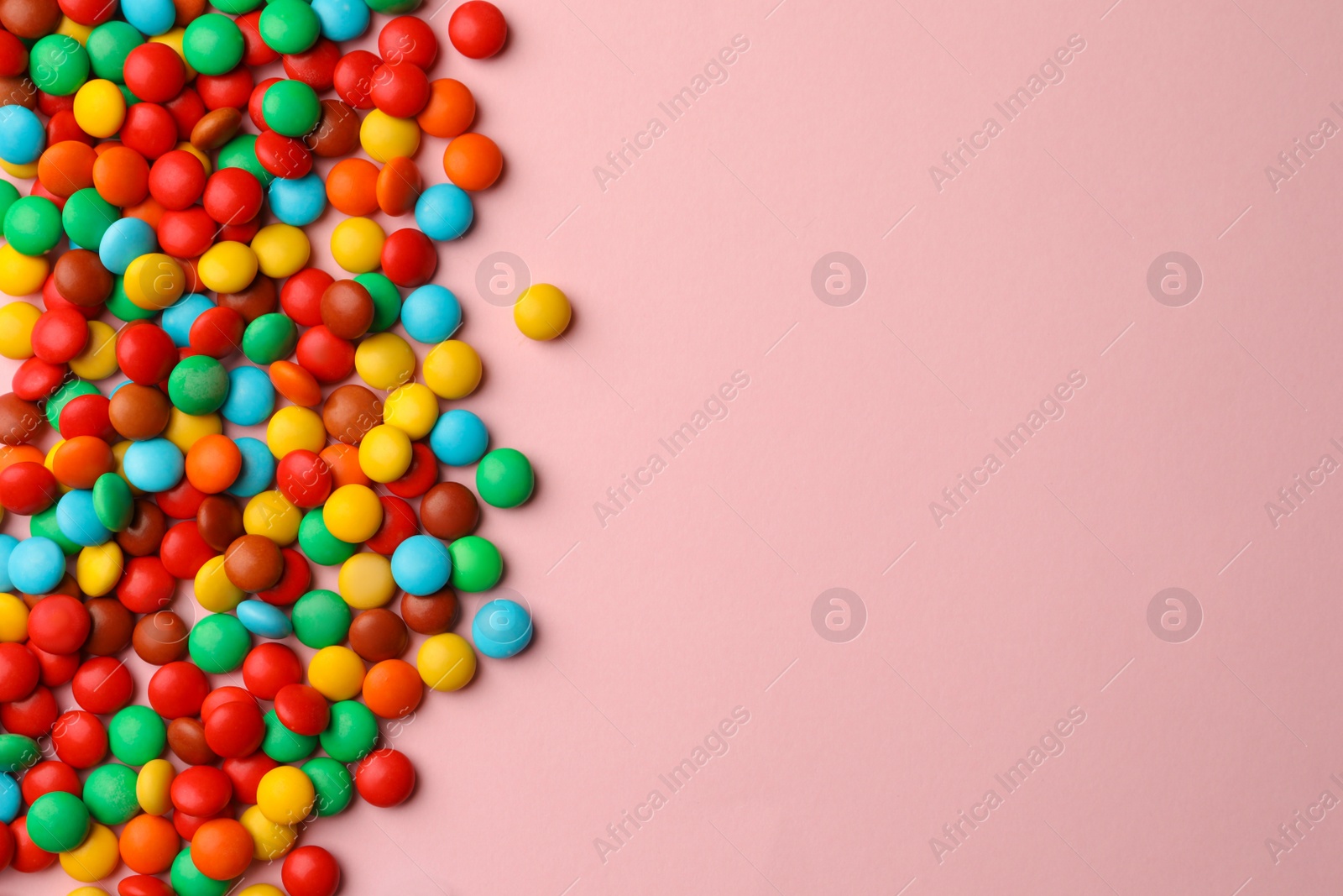 Photo of Tasty colorful candies on pink background, flat lay. Space for text