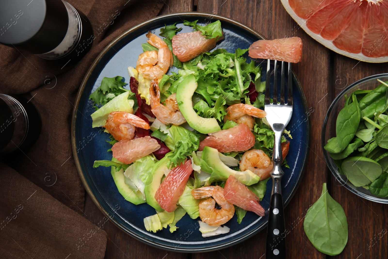 Photo of Delicious pomelo salad with shrimps served on wooden table, flat lay