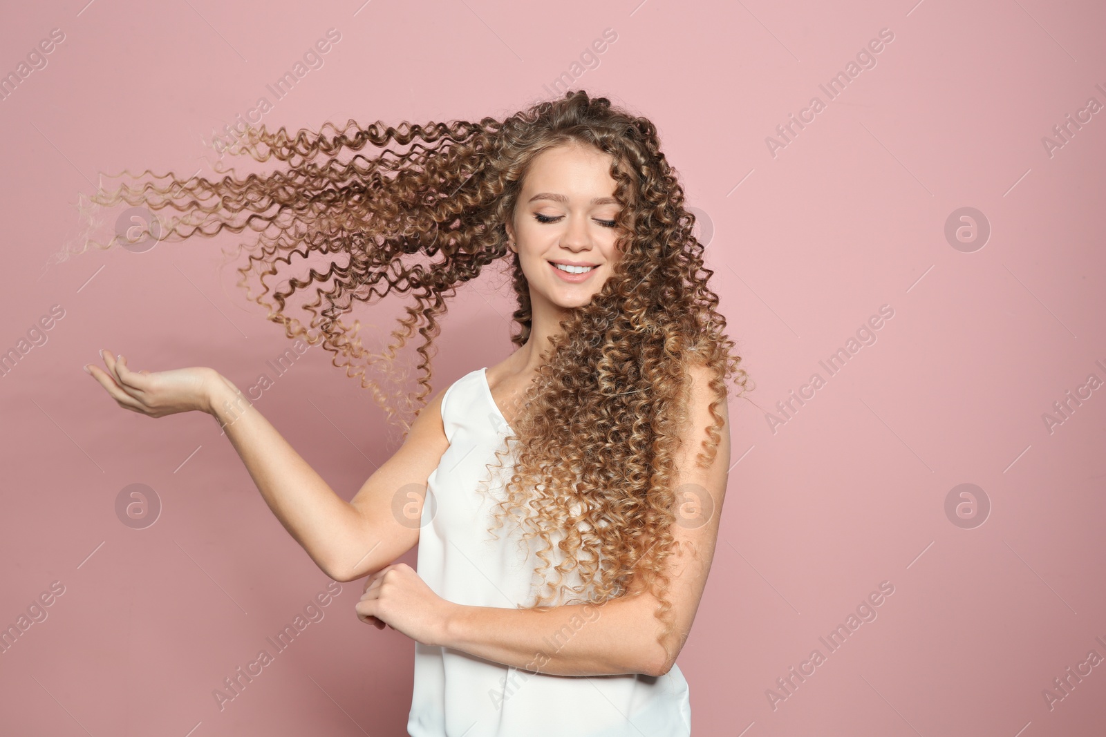 Photo of Portrait of beautiful young woman with shiny wavy hair on color background