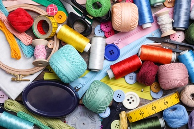 Sewing threads and accessories on table, top view