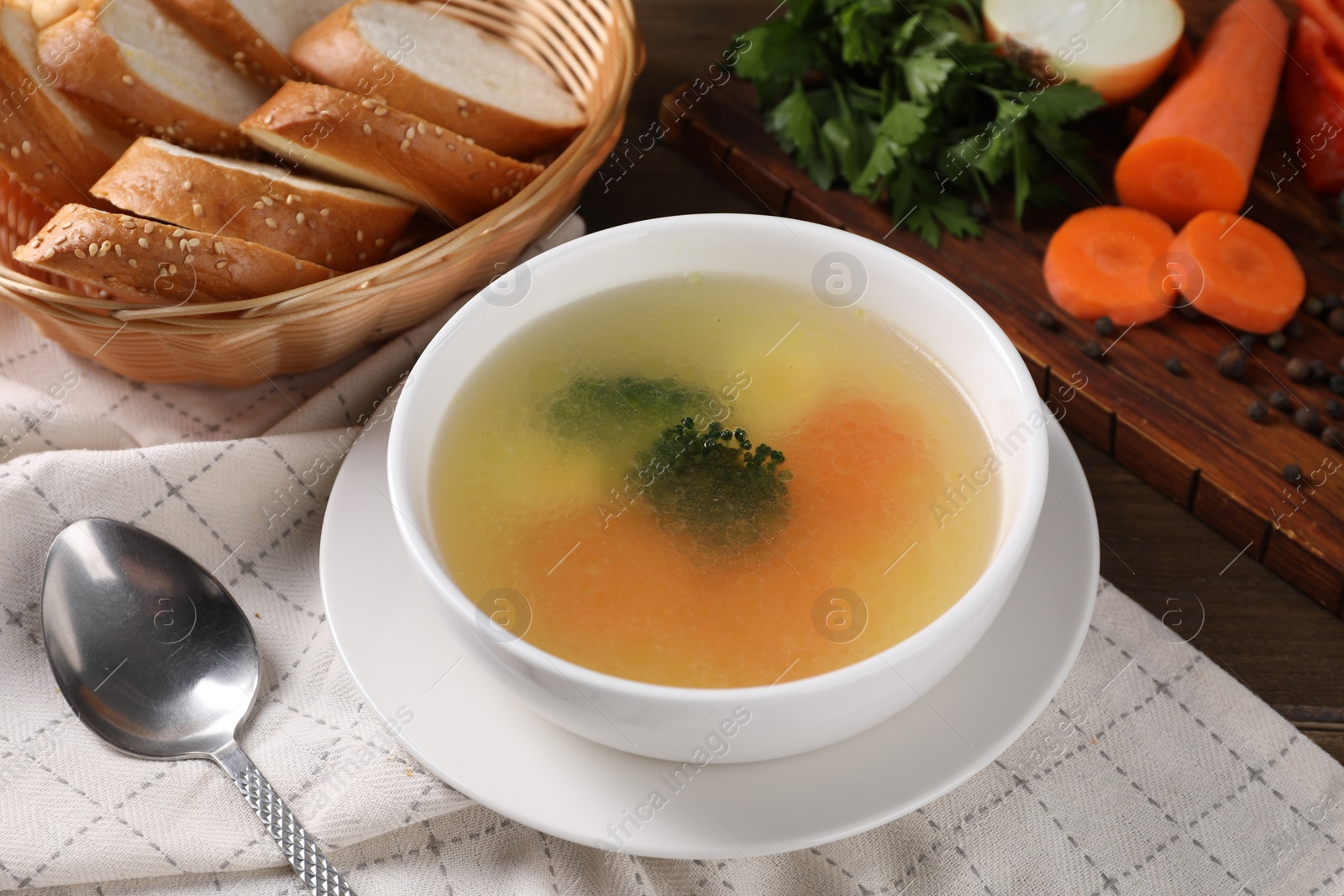 Photo of Tasty soup with vegetables in bowl served on wooden table