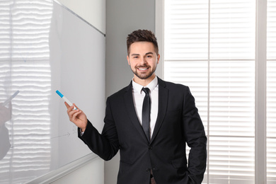 Photo of Professional business trainer near whiteboard in office