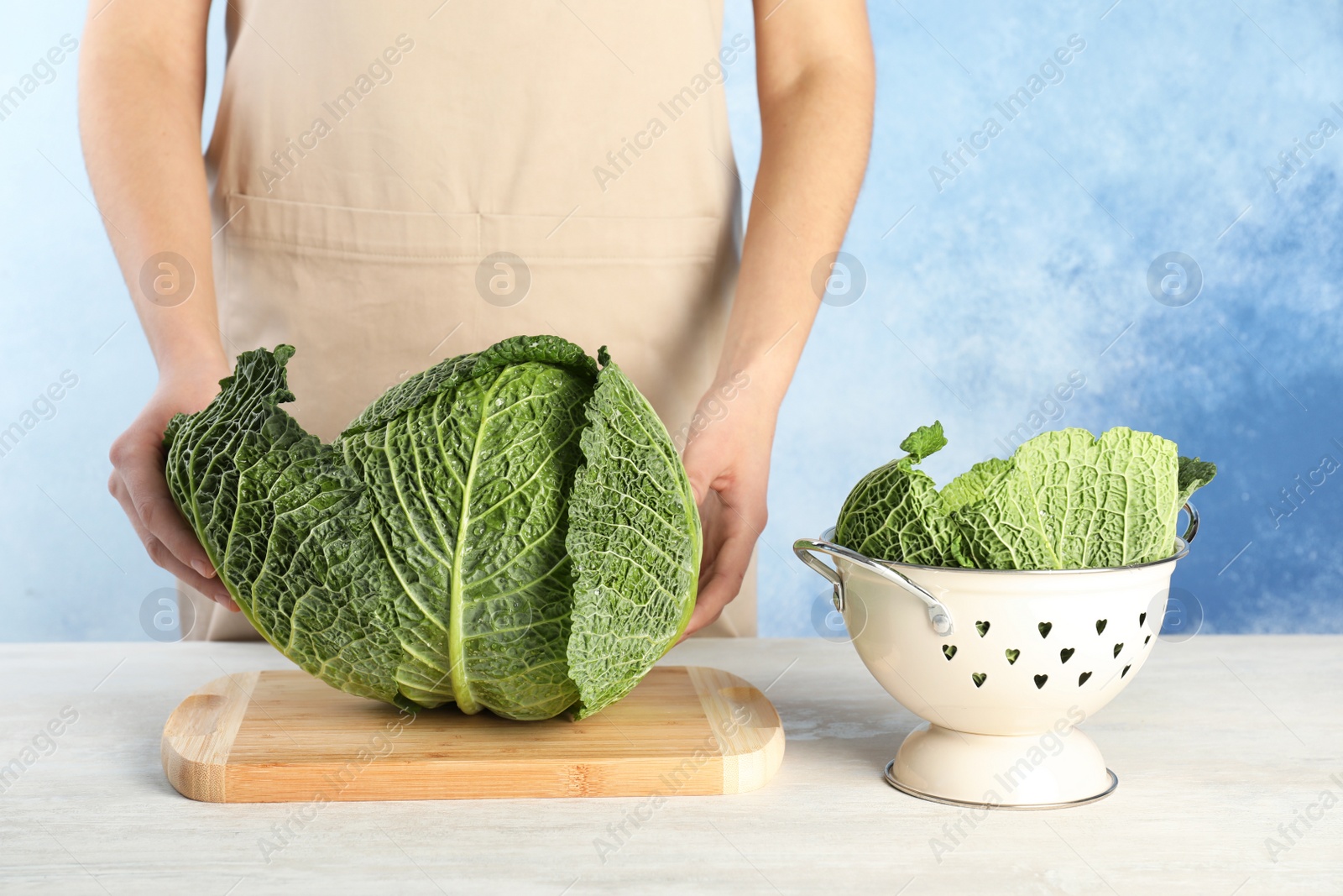 Photo of Woman with fresh savoy cabbage at table