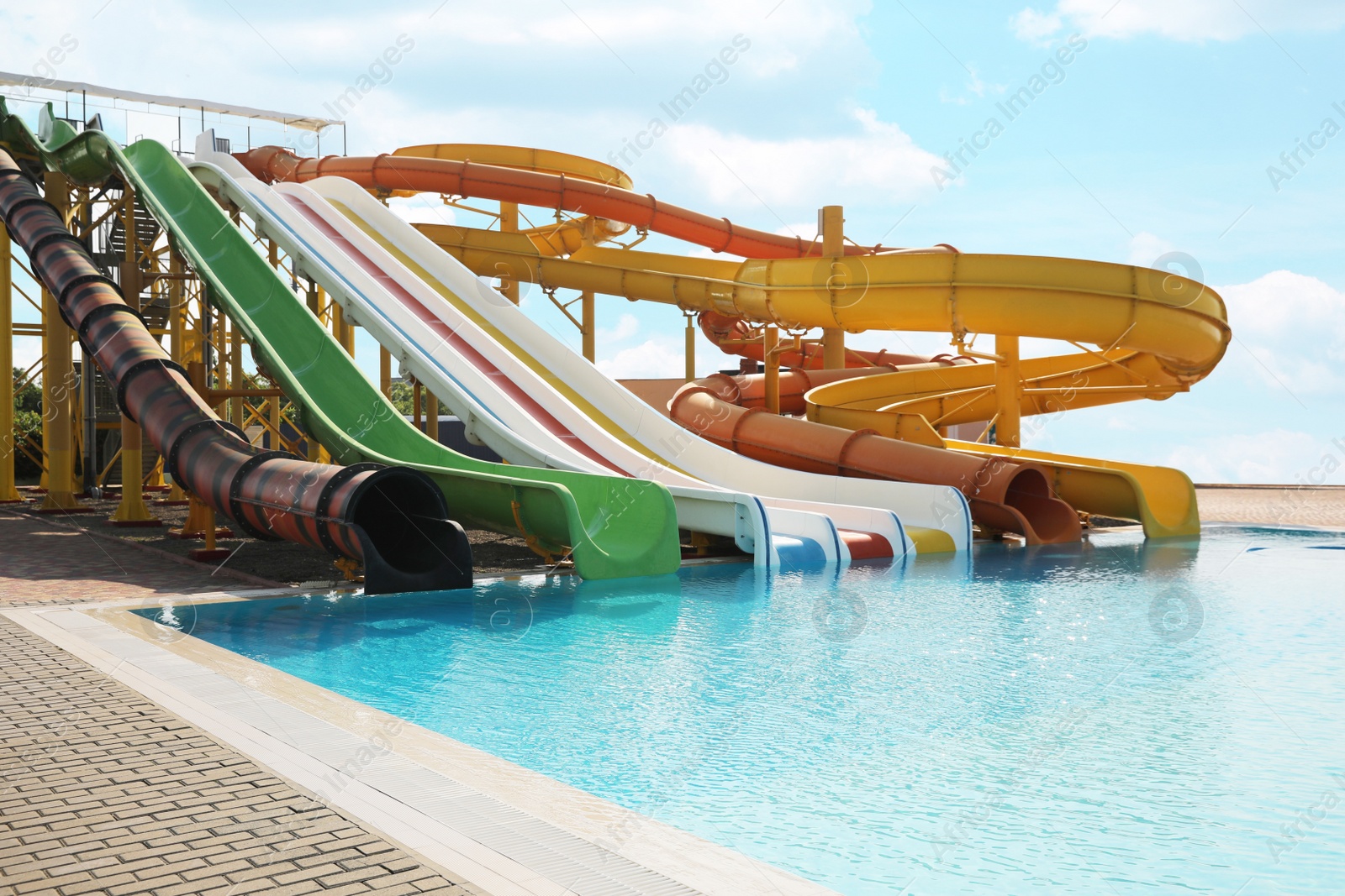 Photo of Beautiful view of water park with colorful slides and swimming pool on sunny day