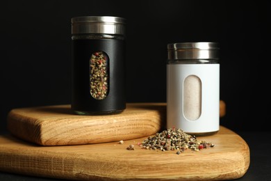 Photo of Salt and pepper shakers on table against black background