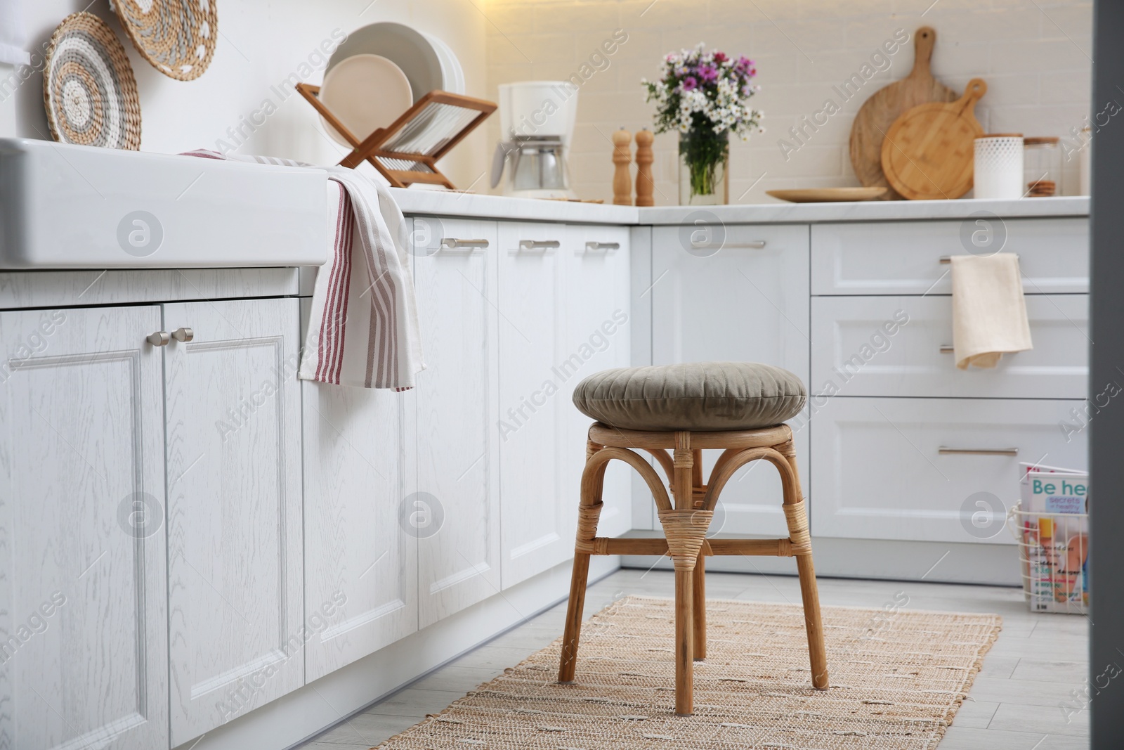 Photo of Stylish kitchen interior with wooden stool and other furniture