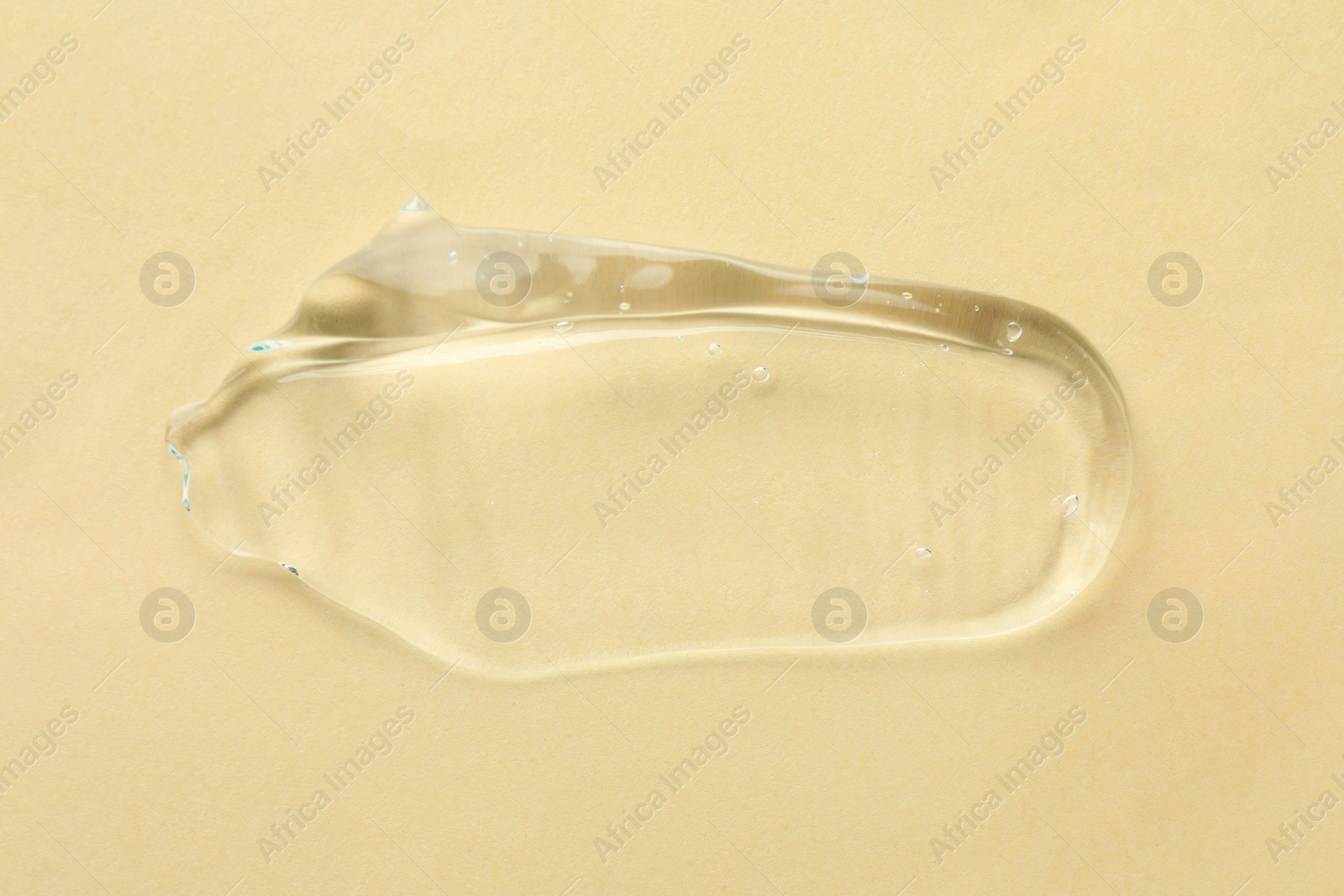 Photo of Clear cosmetic gel on beige background, top view