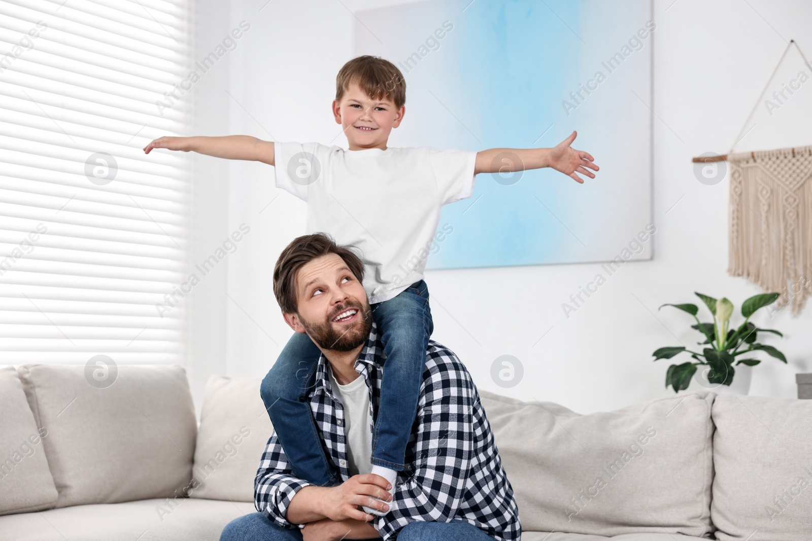 Photo of Happy dad and son having fun at home