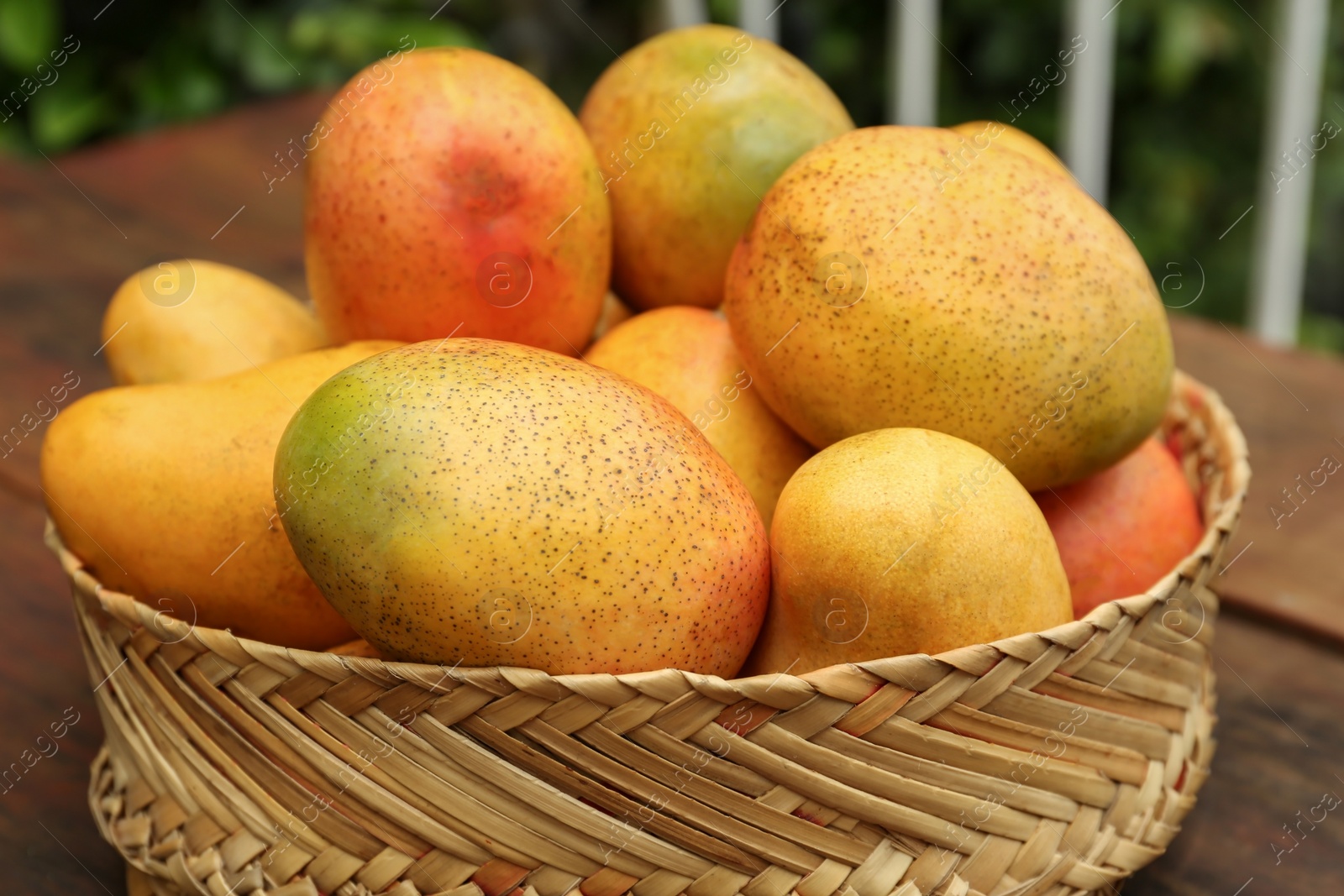 Photo of Delicious ripe juicy mangos on wooden table, closeup