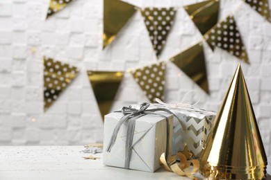 Photo of Gifts and party cones on table against blurred background