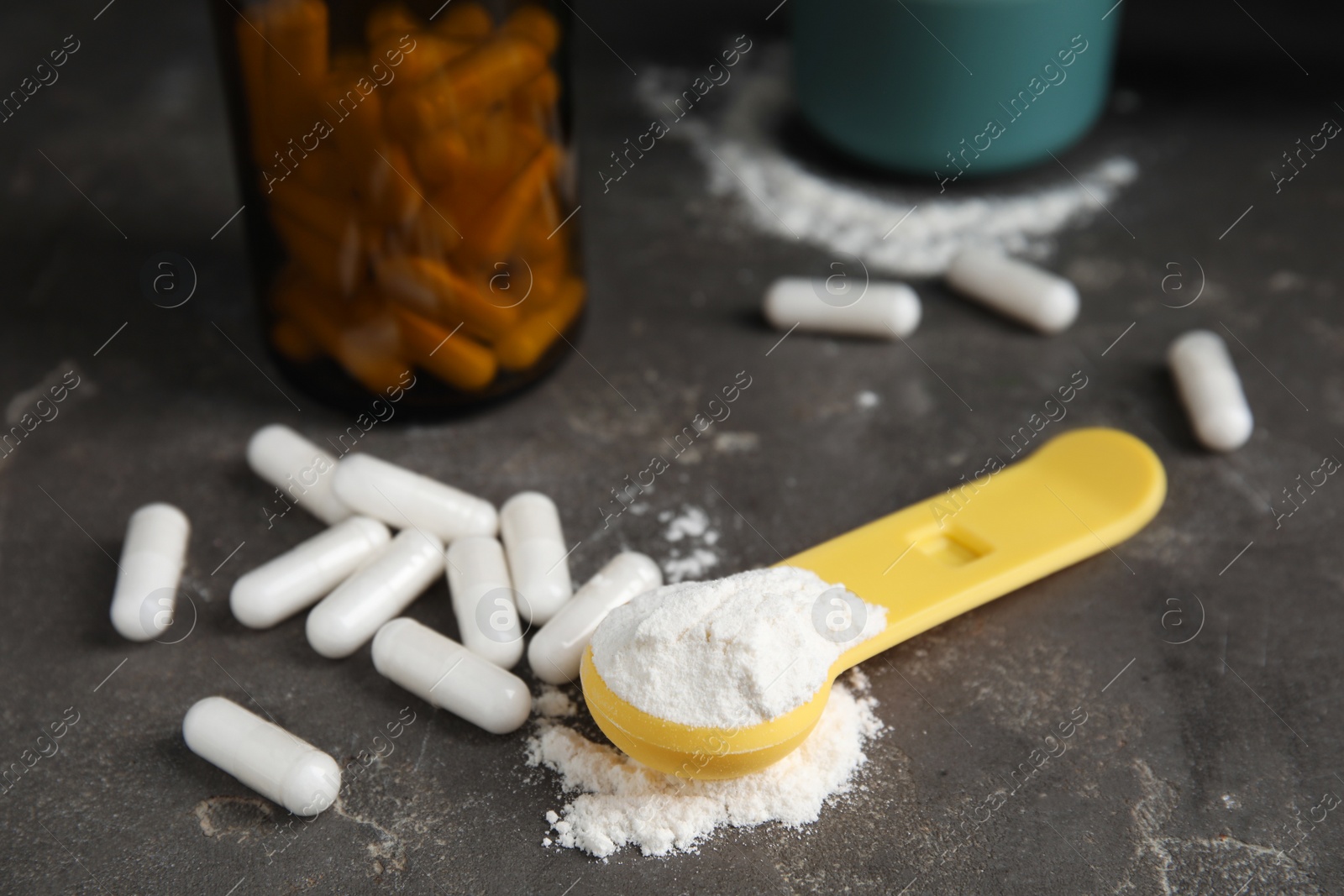 Photo of Amino acid pills and powder on grey table