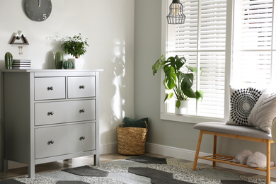 Grey chest of drawers in stylish room interior