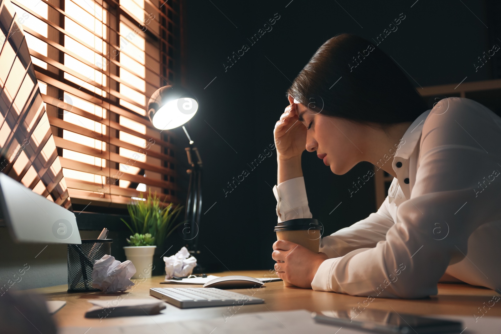 Photo of Businesswoman stressing out at workplace late in evening