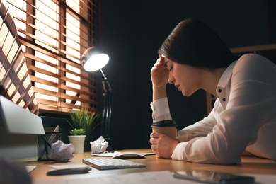 Photo of Businesswoman stressing out at workplace late in evening