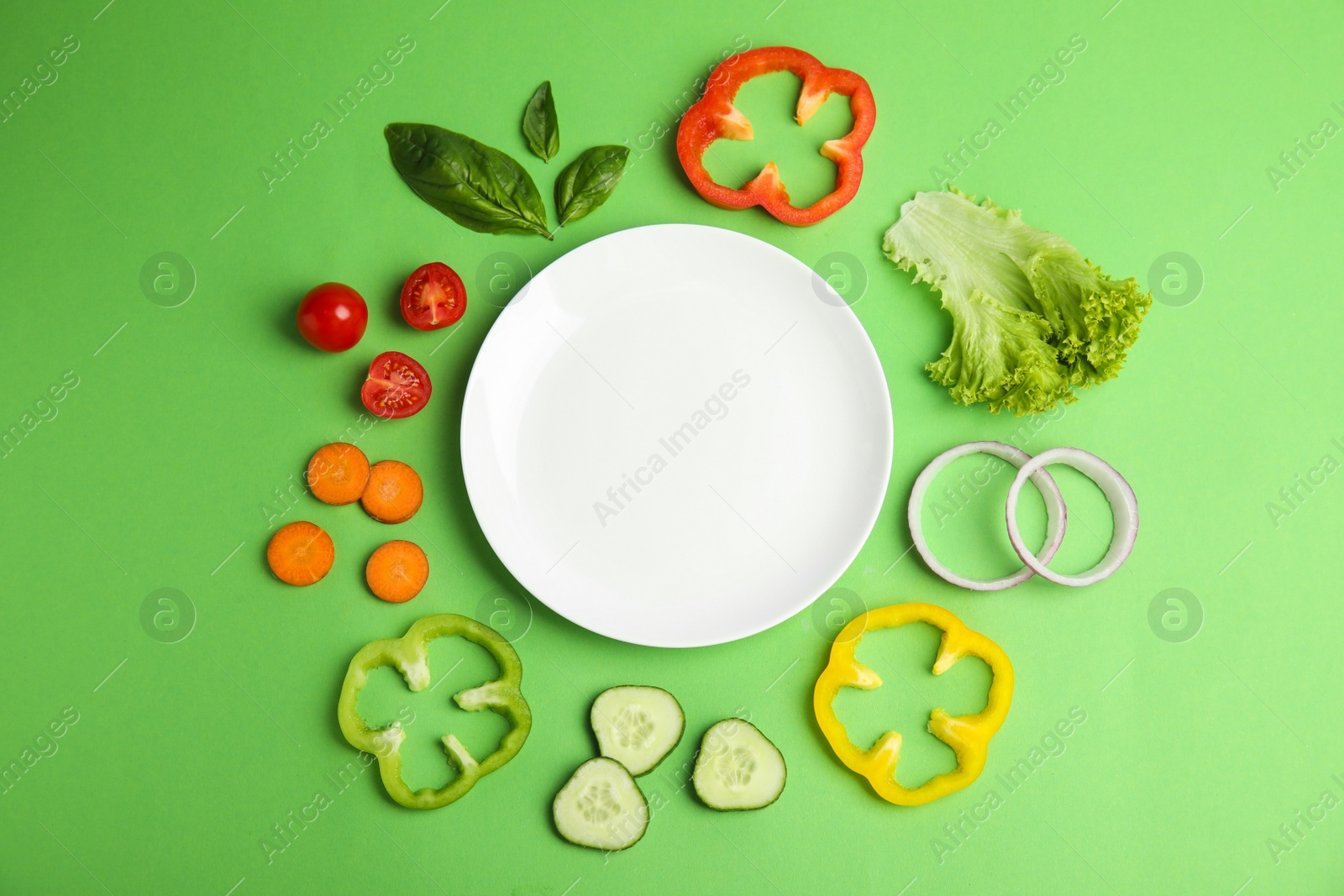 Photo of Flat lay composition with fresh salad ingredients on green background, space for text