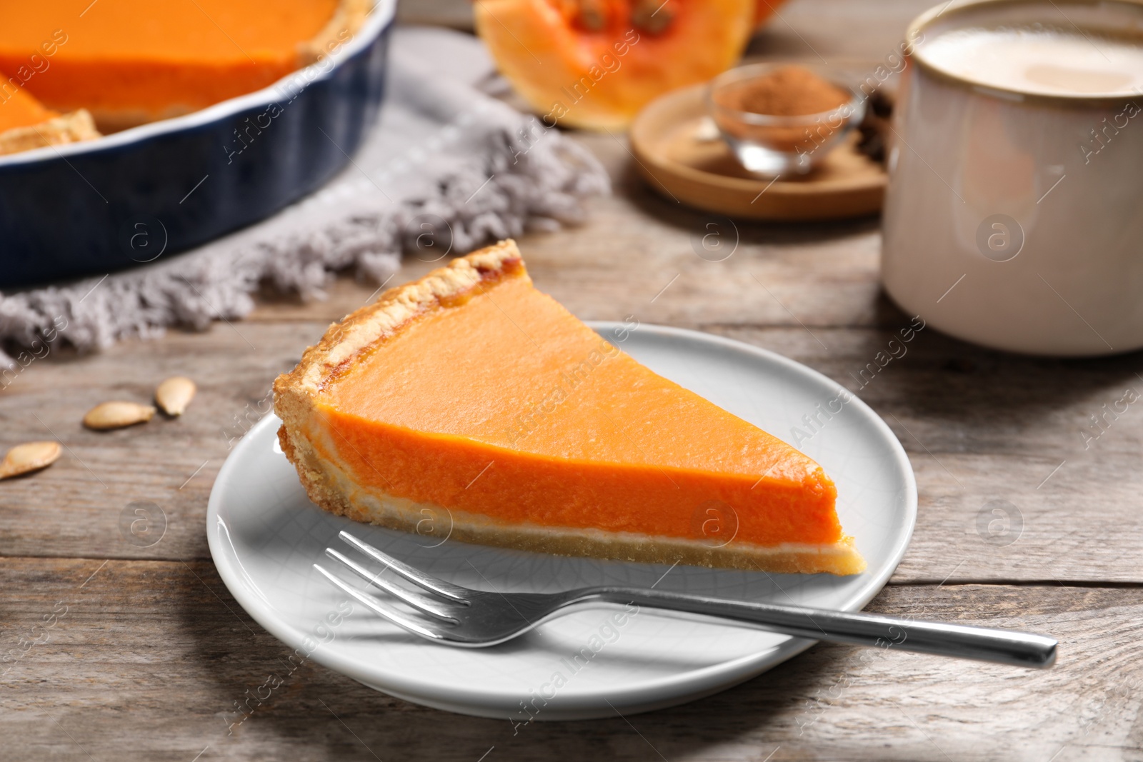 Photo of Plate with piece of fresh delicious homemade pumpkin pie on wooden table