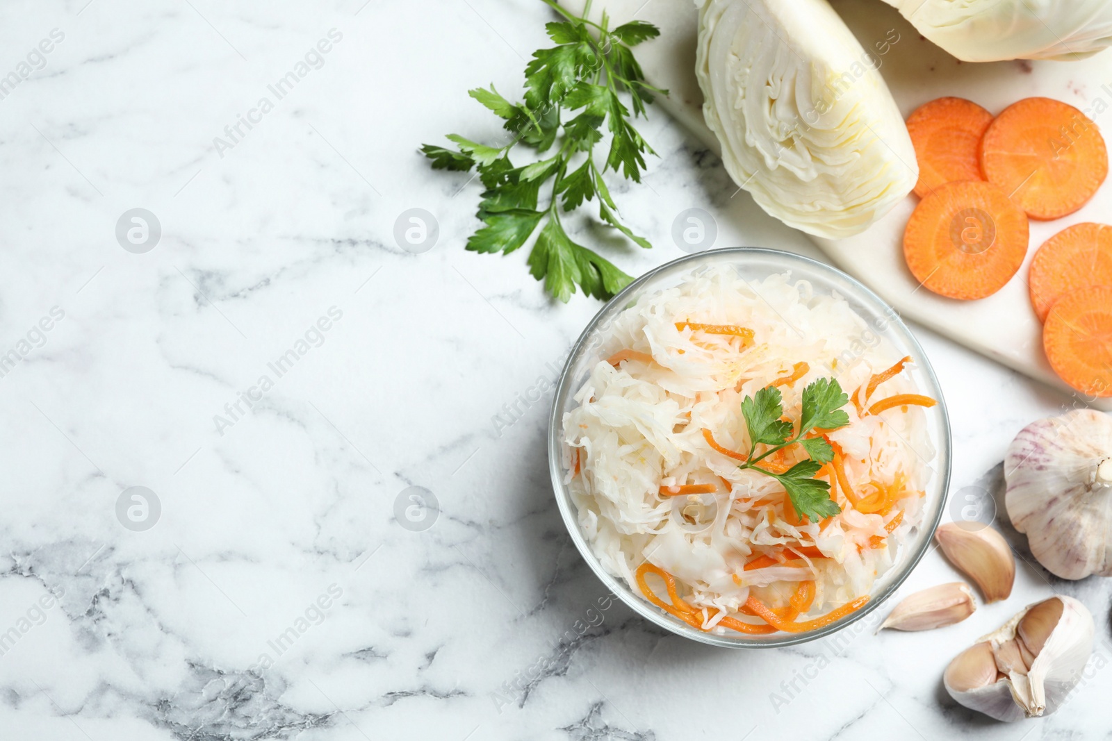 Photo of Flat lay composition with fermented cabbage on white marble table, space for text