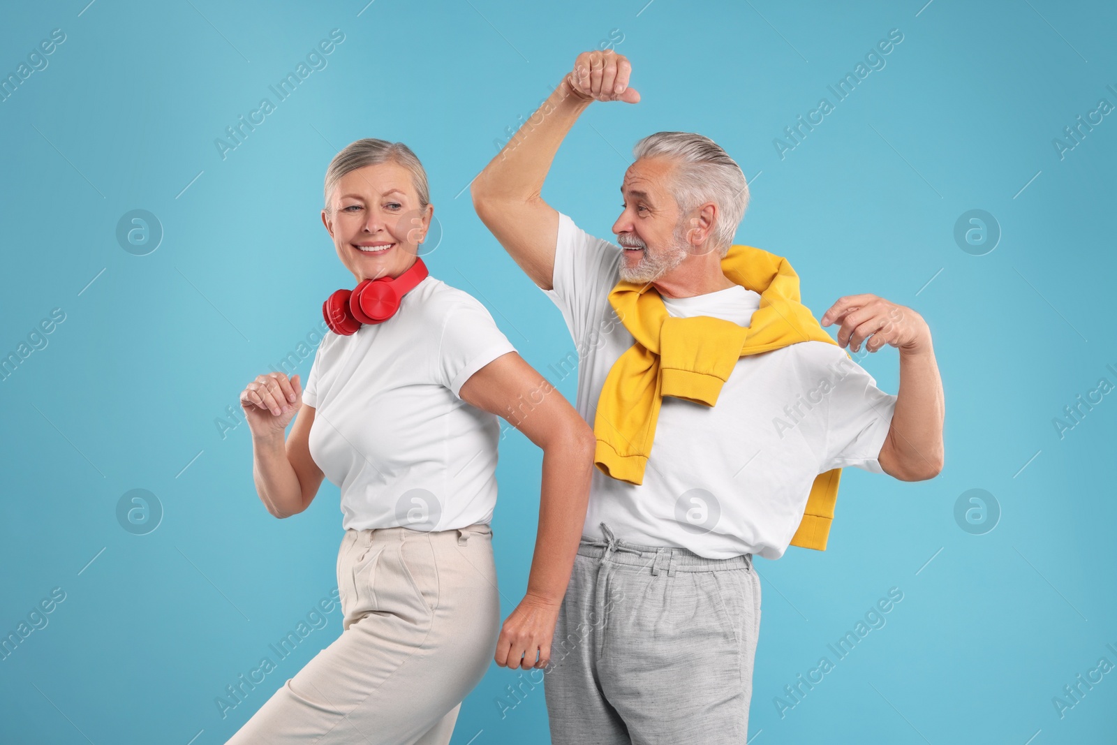 Photo of Senior couple dancing together on light blue background