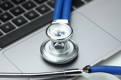 Stethoscope and modern laptop on grey table, closeup