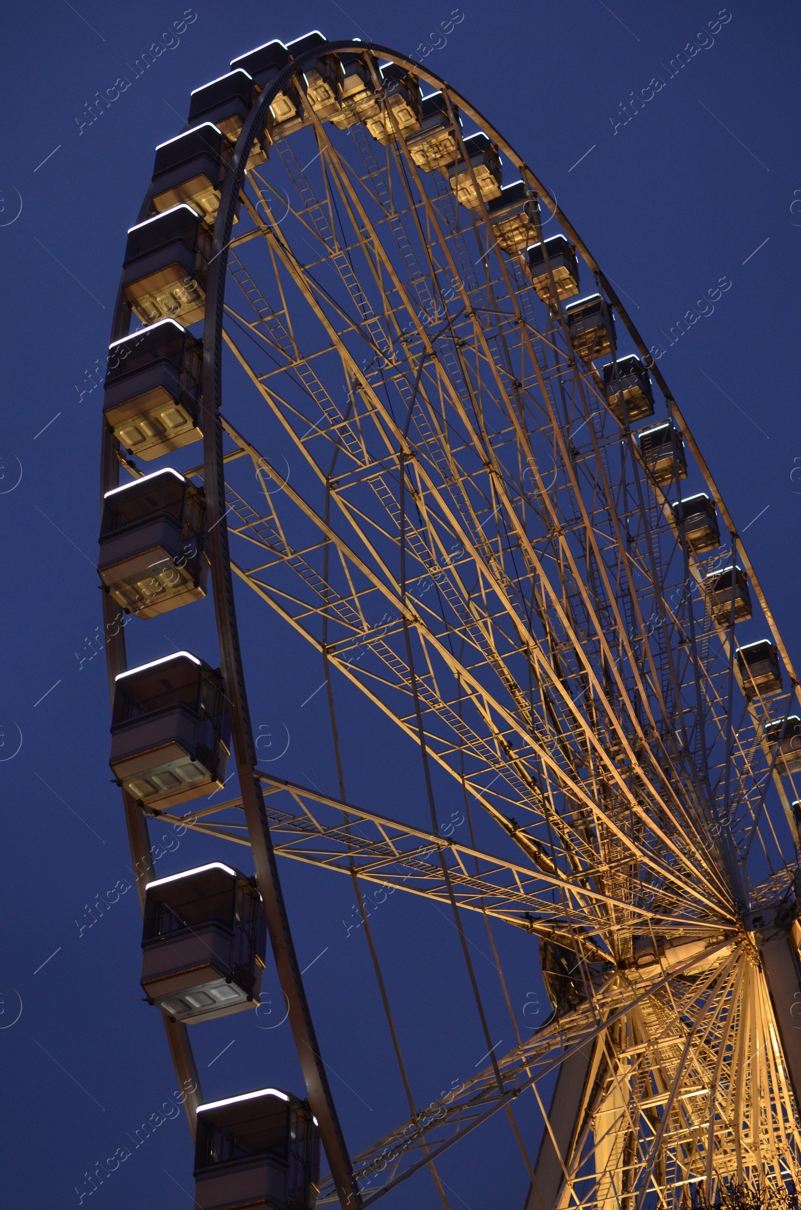 Photo of Beautiful large Ferris wheel against dark sky, low angle view