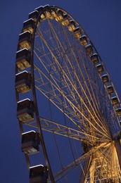 Beautiful large Ferris wheel against dark sky, low angle view