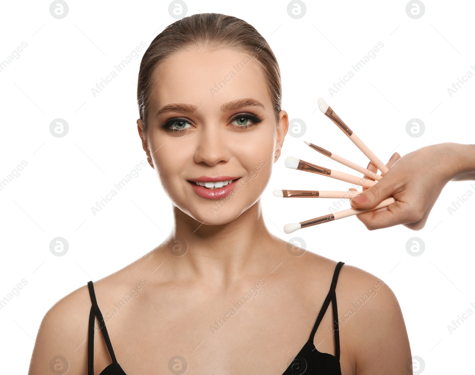 Photo of Beautiful woman with stylish makeup and brushes on white background