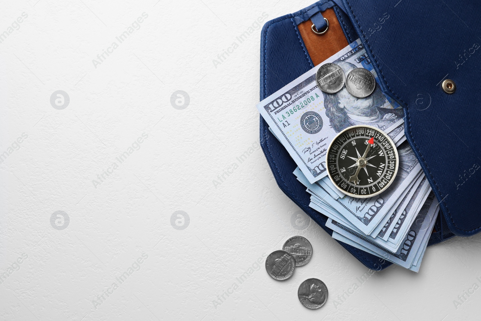 Image of Exchange rate. Wallet with money (dollar banknotes and coins) and compass on white background, top view. Space for text