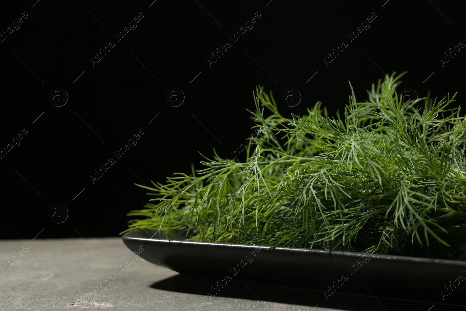 Photo of Fresh green dill on grey table, closeup. Space for text
