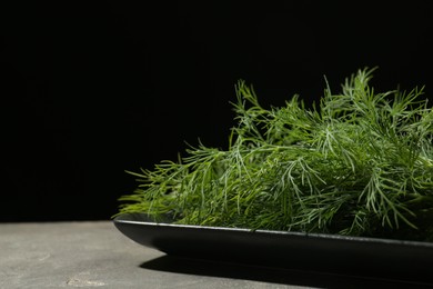 Fresh green dill on grey table, closeup. Space for text