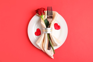 Photo of Beautiful table setting for romantic dinner on red background, top view. Valentine's day celebration