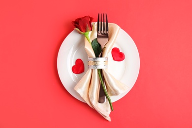 Beautiful table setting for romantic dinner on red background, top view. Valentine's day celebration