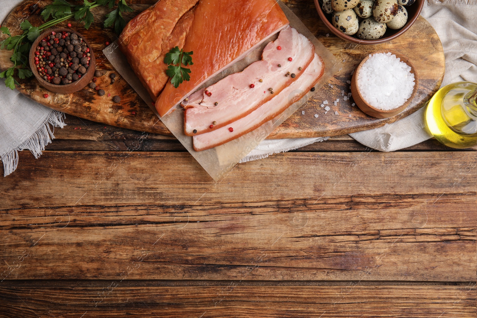 Photo of Flat lay composition with delicious smoked bacon on wooden table, space for text