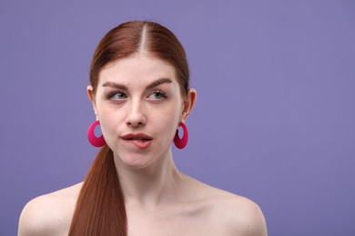 Photo of Portrait of beautiful woman with freckles on purple background. Space for text