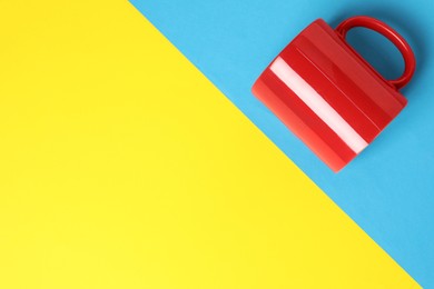 Photo of One red ceramic mug on color background, top view. Space for text