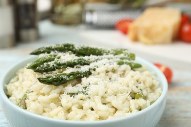 Photo of Delicious risotto with asparagus and cheese in bowl, closeup