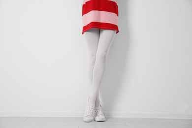 Photo of Woman wearing tights near white wall, closeup